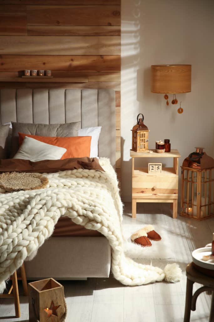 Ambiance Cocooning Chambre : Déco Hivernale Chaleureuse Chambre cocon hivernale avec tête de lit matelassée, jeté tricoté crème épais, bougies et décorations en bois pour une ambiance chaleureuse. Date: 25 Septembre.